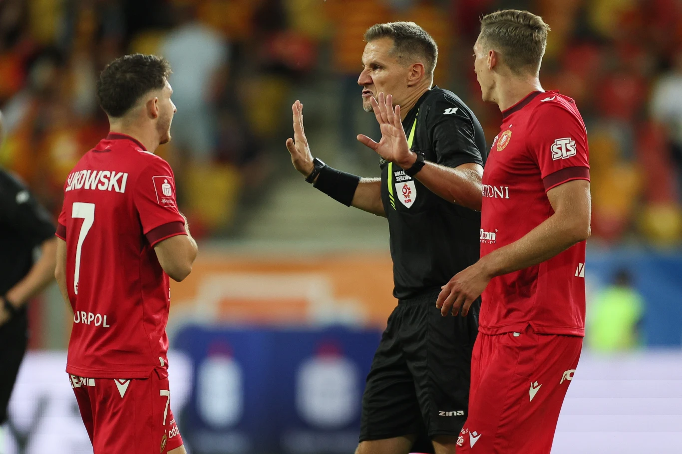 Piłkarze Widzewa dyskutujący z arbitrem