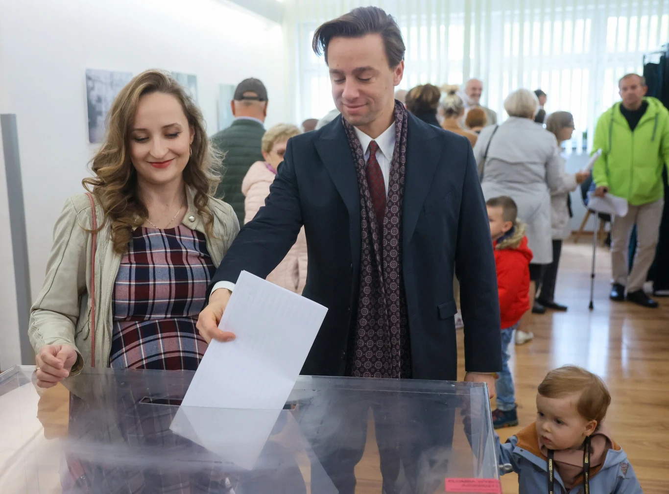 Krzysztof Bosak z żoną Kariną i dziećmi oddaje swój głos w wyborach parlamentarnych w Miejskim Ośrodku Kultury w Józefowie