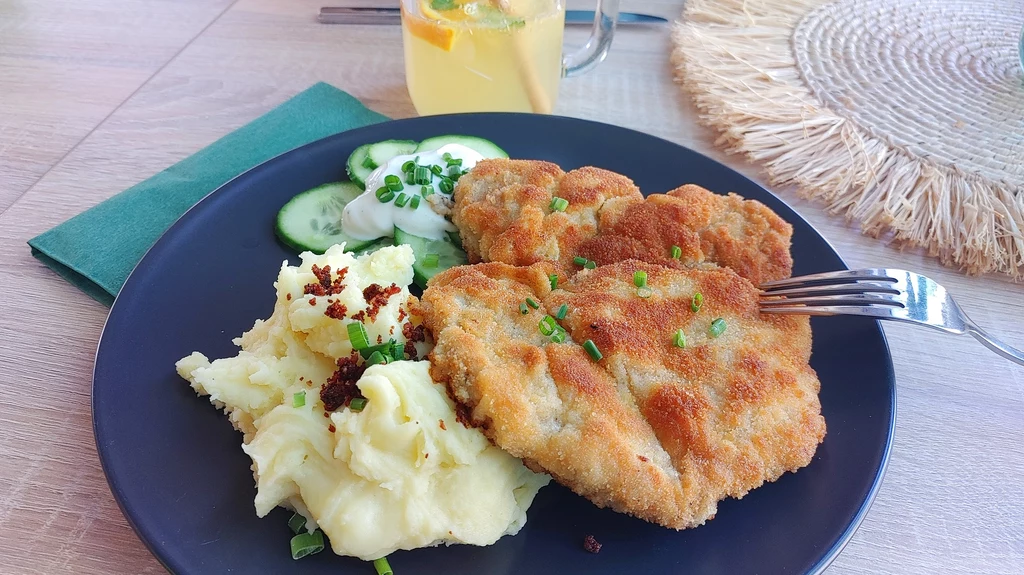 Kotlet schabowy z ziemniakami i mizerią to tradycyjne polskie danie.