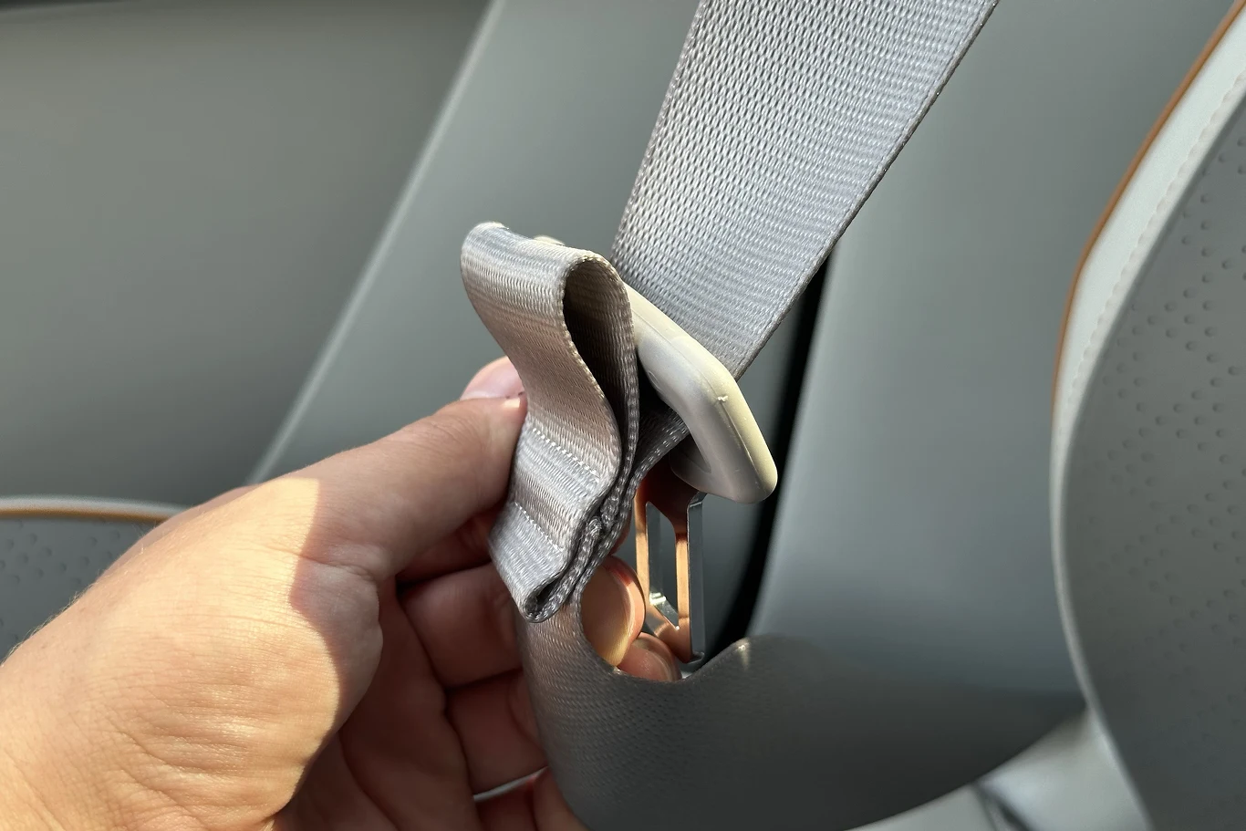 Po co stosuje się niewielki, plastikowy element na pasach bezpieczeństwa? 