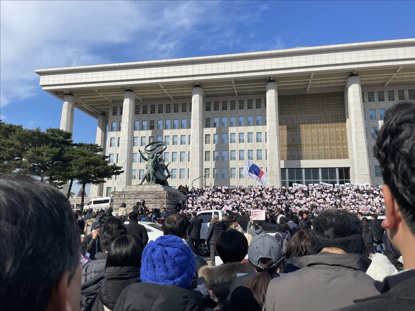 Ludzie zgromadzeni przed budynkiem Zgromadzenia Narodowego protestują po ogłoszeniu stanu wojennego w Seulu Ludzie zgromadzeni przed budynkiem Zgromadzenia Narodowego protestują po ogłoszeniu stanu wojennego w Seulu