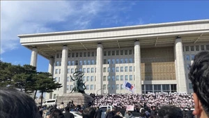 Ludzie zgromadzeni przed budynkiem Zgromadzenia Narodowego protestują po ogłoszeniu stanu wojennego w Seulu 