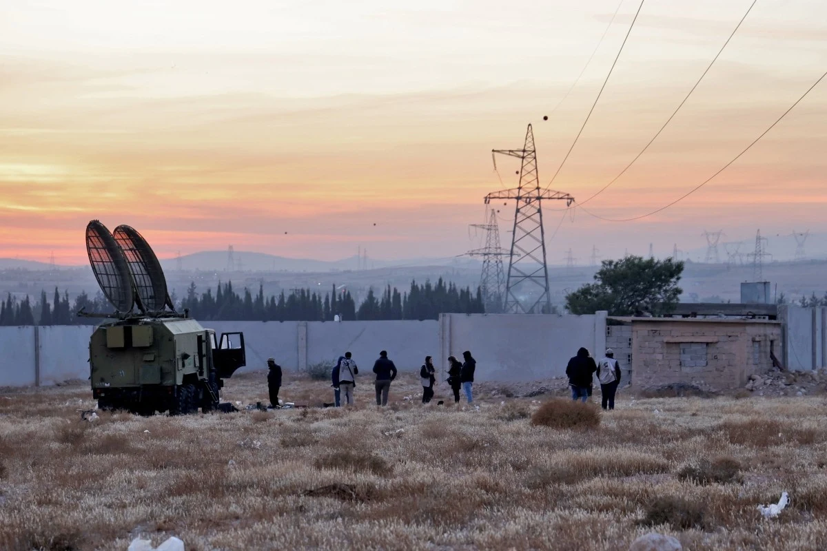 Ludzie szukają masowego grobu w pobliżu radaru samochodowego porzuconego przez syryjską armię w bazie wojskowej w Al-Kutajfa Ludzie szukają masowego grobu w pobliżu radaru samochodowego porzuconego przez syryjską armię w bazie wojskowej w Al-Kutajfa