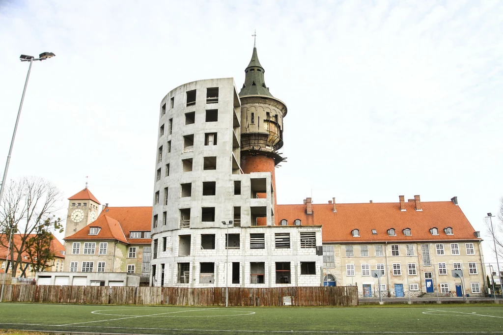 Wieża ciśnień w Szczytnie opleciona jest szpecącym, betonowym szkieletem budowanego od lat apartamentowca