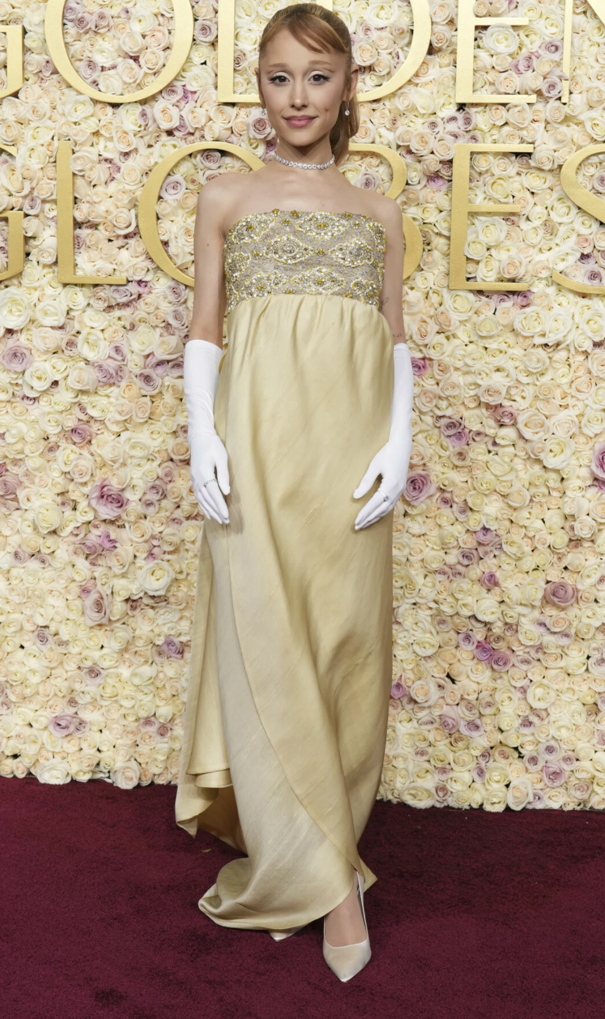 Ariana Grande w złotej sukni oraz białych rękawiczkach