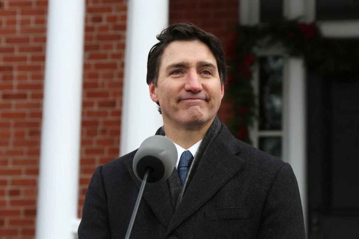 Justin Trudeau, wieloletni premier Kanady, będzie gościem specjalnym Impact'26 w Poznaniu Justin Trudeau elegancko ubrany przed mikrofonem. W tle budynek z cegły.