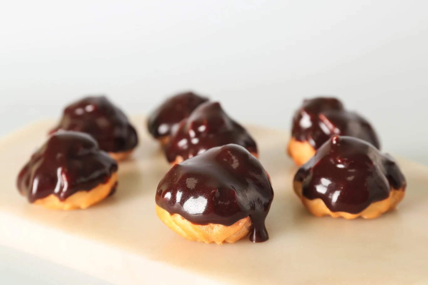 Mini parzone pączki z czekoladowym kremem i polewą to deser idealny na karnawał Mini parzone pączki z czekoladowym kremem i polewą to deser idealny na karnawał