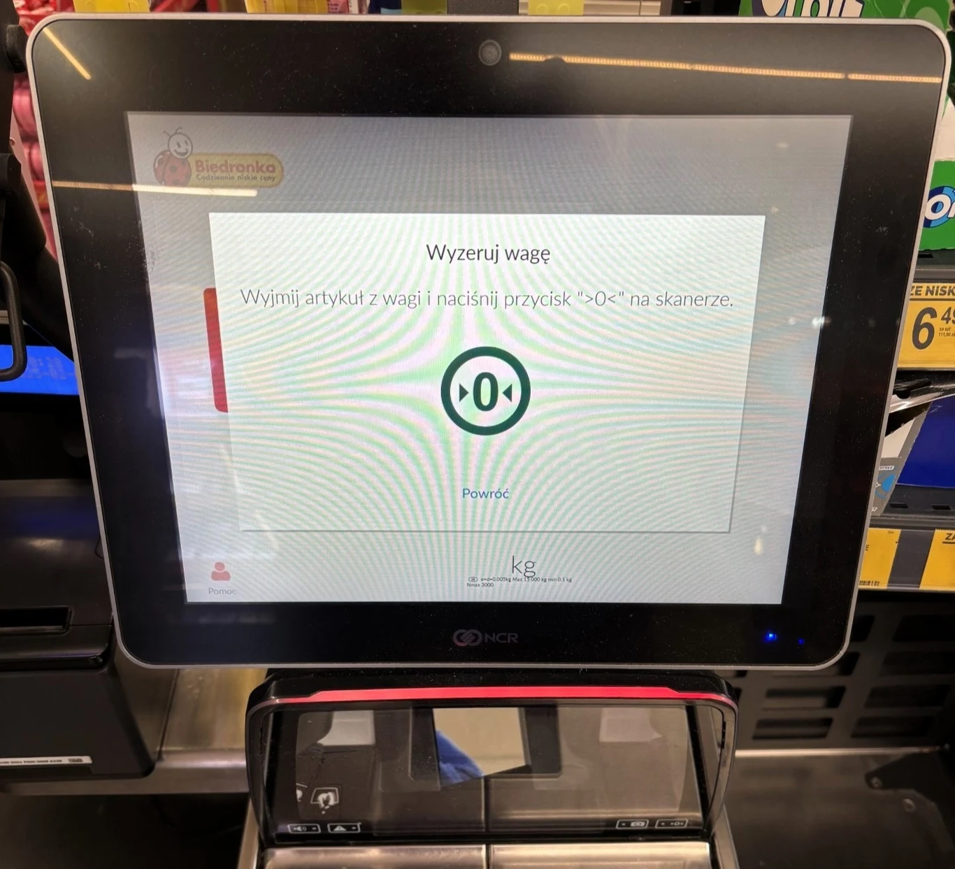 Komunikat wyświetlany na kasie samoobsługowej w Biedronce dotyczący nieprawidłowego działania wagi. Na ekranie wskazane jest, co należy zrobić. Komunikat wyświetlany na kasie samoobsługowej w Biedronce dotyczący nieprawidłowego działania wagi. Na ekranie wskazane jest, co należy zrobić.