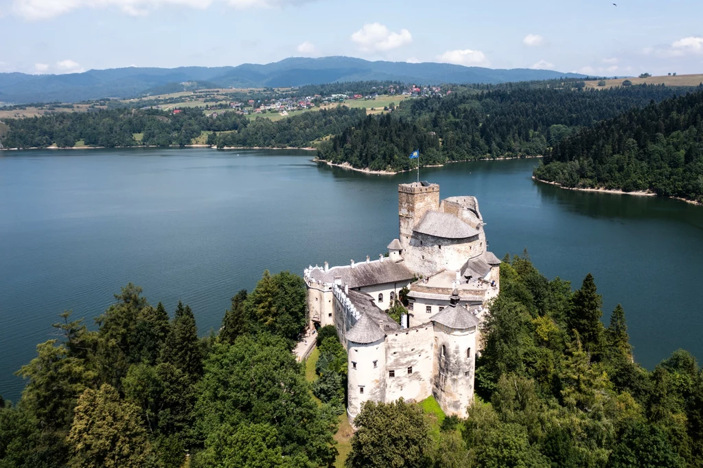 Opadająca woda Zbiornika Czorsztyńskiego ujawniła pozostałości historii miejsca (Fot. Zamek Dunajec w Niedzicy na tle sztucznego jeziora)