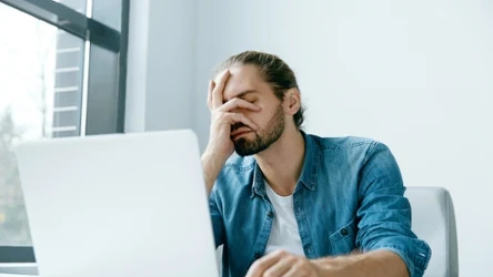 Zmęczony, zmartwiony mężczyzna przed komputerem