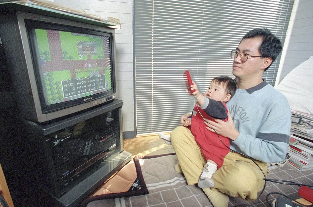 Akira Toriyama z synem podczas gry na konsoli. Akira Toriyama z synem podczas gry na konsoli.
