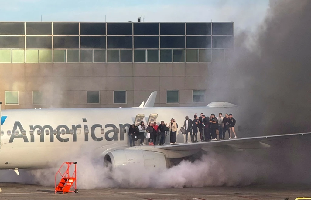 Pasażerowie stojący na skrzydle samolotu American Airlines, ewakuowani po tym, jak maszyna się zapaliła