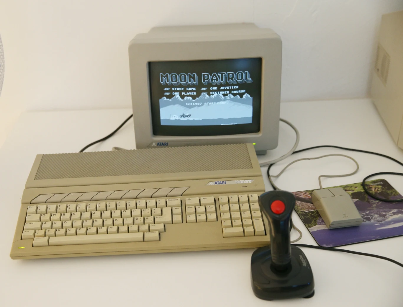 Komputer Atari 1040ST z joystickiem, z grą Moon Patrol. 