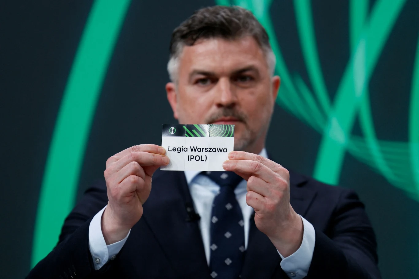 Michał Żewłakow z kartką Legii Warszawa podczas losowania Ligi Konferencji, 21.02.2025 r. Michał Żewłakow z kartką Legii Warszawa podczas losowania Ligi Konferencji, 21.02.2025 r.