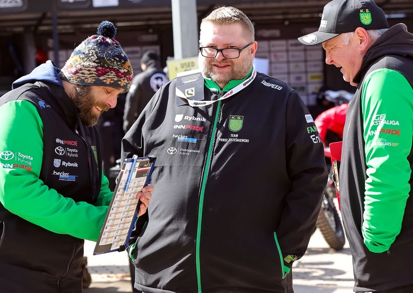 Ksiądz Łukasz Kotyński (w środku) przysłuchuje się rozmowie trenera Piotra Żyto z kierownikiem drużyny Radosławem Kalyciokiem.