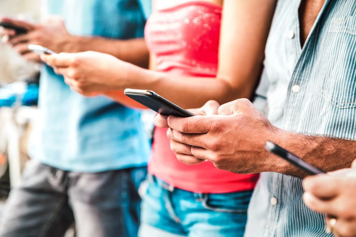 "Zetki" wolą pisać i nagrywać "głosówki" zamiast odebrać telefon Młodzi ludzie z telefonami w rękach
