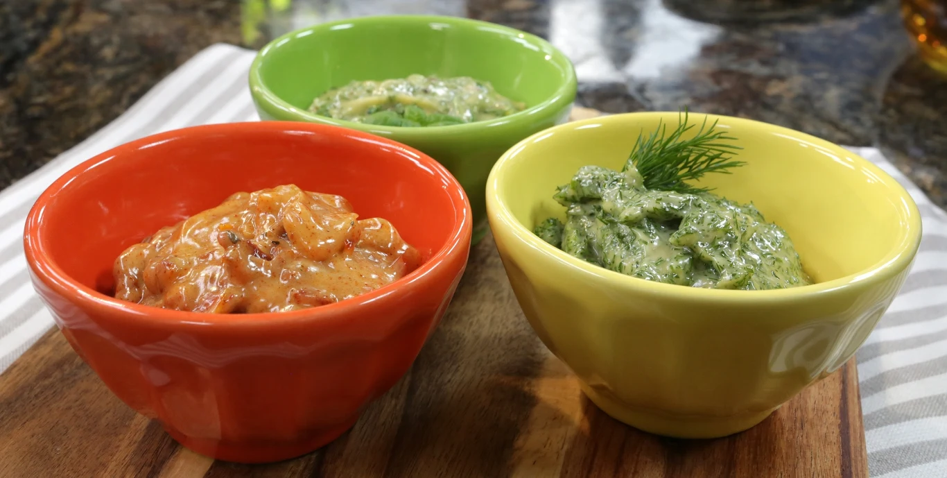 Majonez smakowy Trzy miseczki w różnych kolorach: pomarańczowej, zielonej i żółtej, każda zawiera inny sos. Sos w pomarańczowej miseczce ma czerwonkawy odcień, w zielonej jasny zielony, a w żółtej ciemnozielony z gałązką koperku na wierzchu.