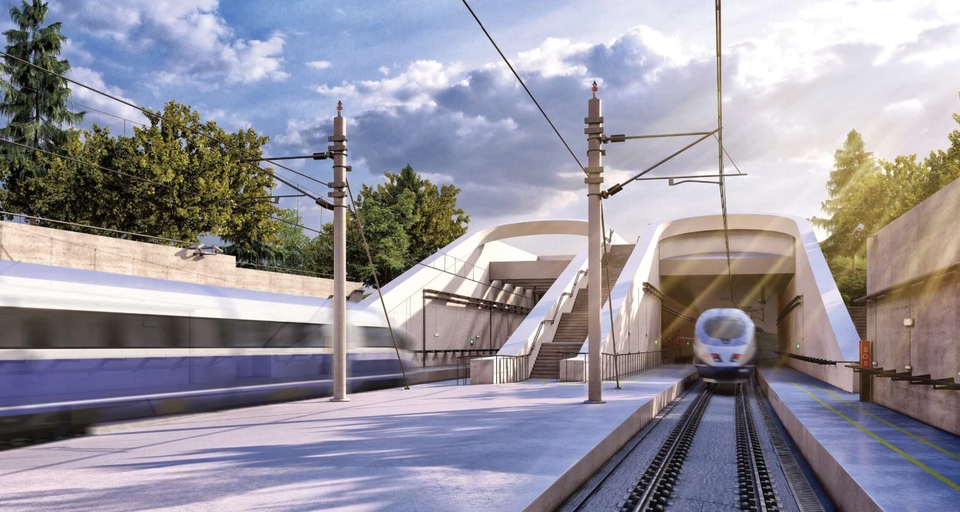 Najdłuższy tunel kolejowy w Polsce. Zbuduje go CPK. Nowoczesny dworzec kolejowy z dwoma peronami i pociągami dużych prędkości. Na jednym torze znajduje się pociąg w ruchu, a po przeciwnej stronie drugi pociąg wjeżdża na stację z tunelu. Całość otoczona zielenią i pod błękitnym niebem.