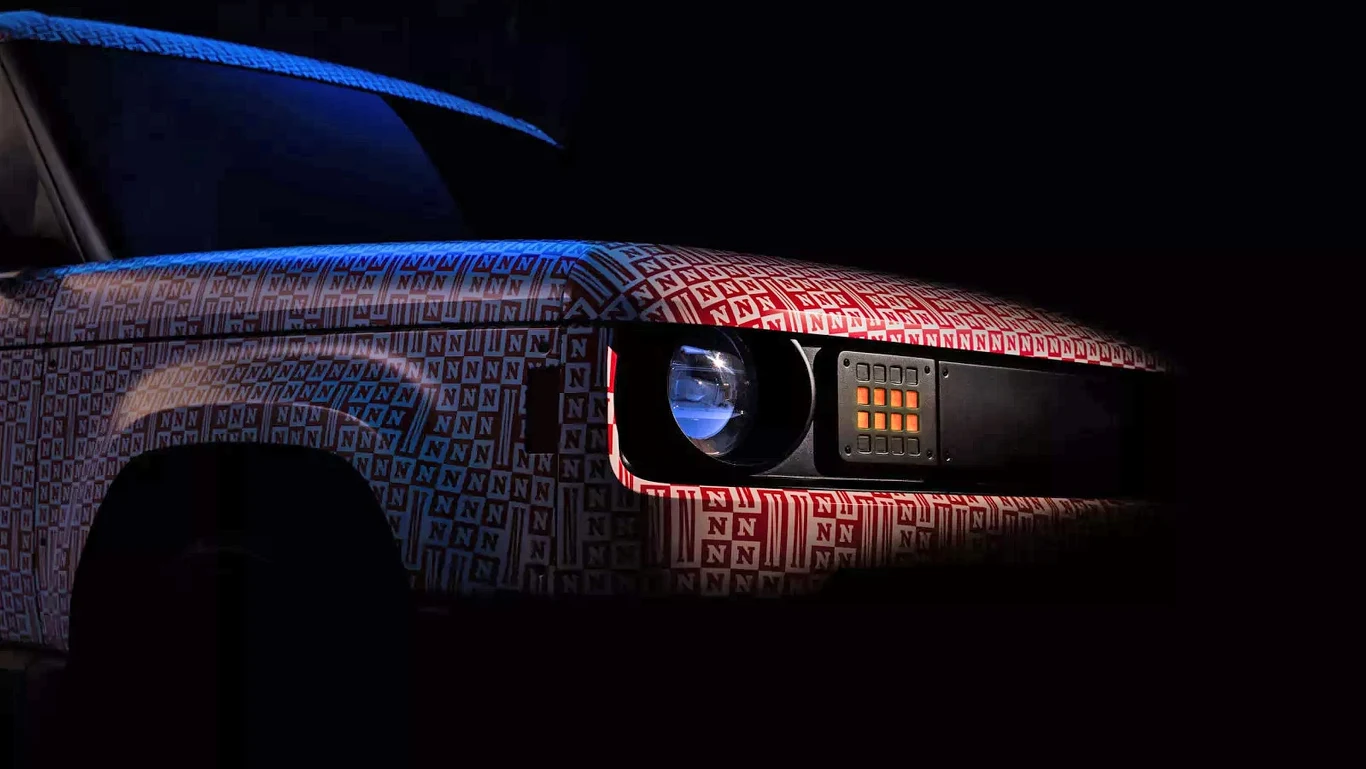 Jeff Bezos zainwestował w pick up Slate Auto. Samochód częściowo pokryty materiałem z logo producenta, ustawiony w tle z mrocznym oświetleniem. Widoczna przednia część auta z reflektorami i grillem.