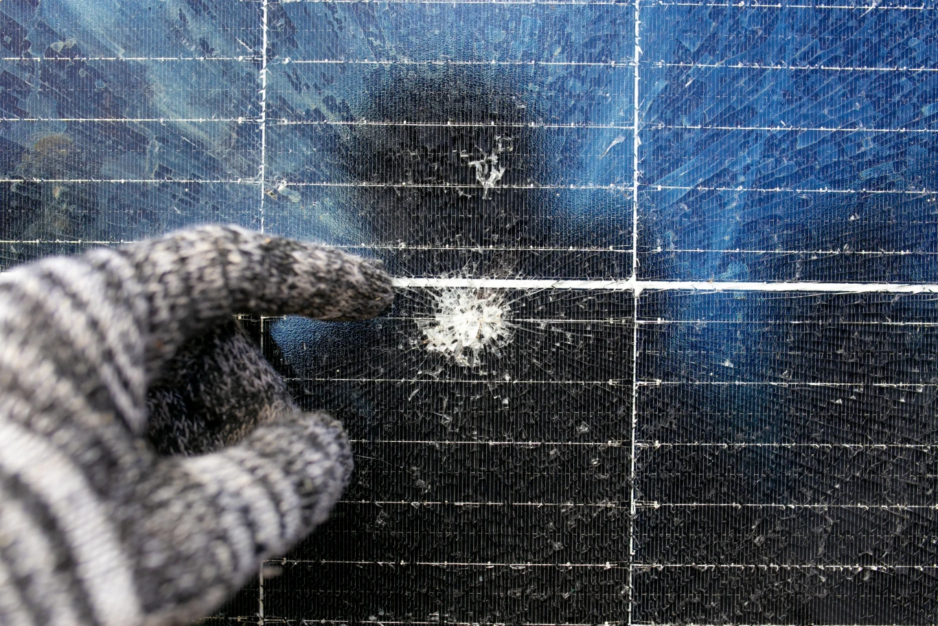 zniszczony panel słoneczny wskazywany przez rękę w rękawiczce