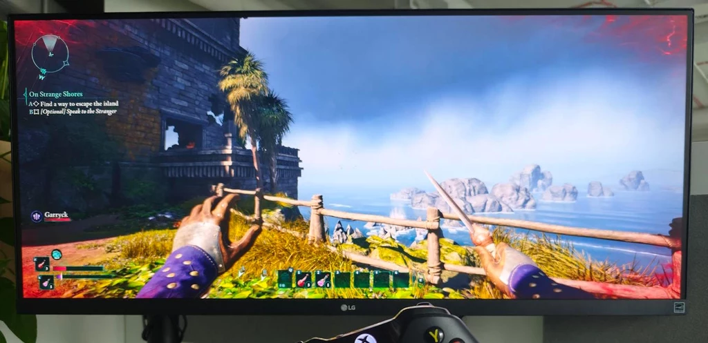 GeForce NOW oferuje użytkownikom elastyczność w wyborze planów subskrypcyjnych Monitor LCD z uruchomioną grą komputerową w trybie pierwszoosobowym. Na ekranie widoczna jest ręka postaci trzymająca drewniane belki oraz krajobraz przedstawiający niebo i wyspę na horyzoncie.