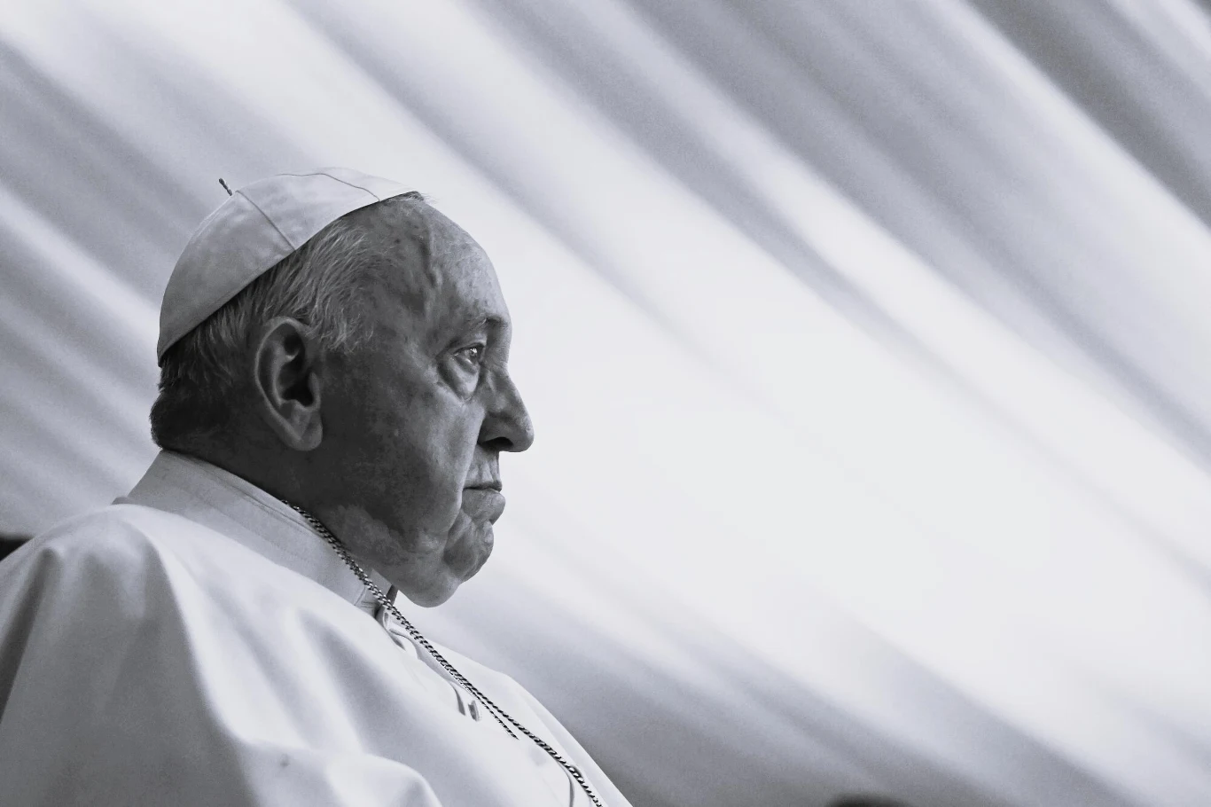 Papież Franciszek nie żyje Papież Franciszek. Czarno-biały portret osoby w stroju liturgicznym w profilu na tle jasnego, rozmytego tła.