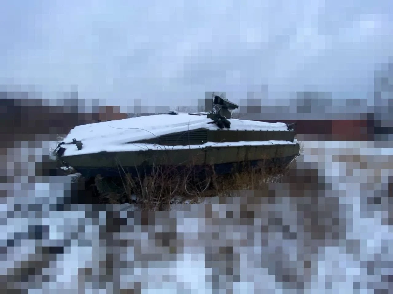 Modernizacja BMP-55 miała zmienić stare czołgi T-55 w nowoczesne bojowe wozy piechoty Pojazd wojskowy pokryty śniegiem stoi na opustoszałym terenie. W tle widać rozmyte drzewa i budynki na horyzoncie. Całość otacza zimowy krajobraz.