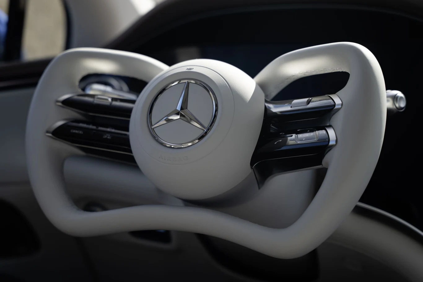 Nowoczesna kierownica samochodu Mercedes, charakteryzująca się eleganckim, futurystycznym designem i doskonałym wykończeniem. Centralna część kierownicy z logo marki, otoczona elementami sterującymi.