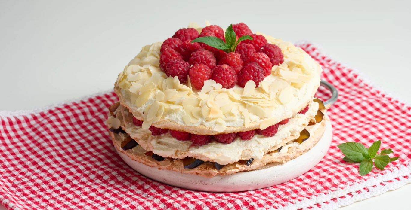 Pyszny tort z bezą, dodatkiem malin i kremem śmietankowym Pyszny tort z bezą, dodatkiem malin i kremem śmietankowym