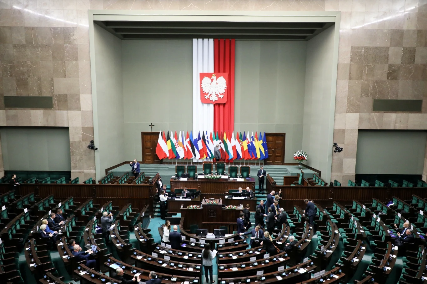 Sondaże CBOS. Polacy oceniają pracę Sejmu i podejście do rządu Donalda Tuska Sala Sejmu RP z flagami różnych krajów oraz godłem Polski, posłowie zajmują miejsca.