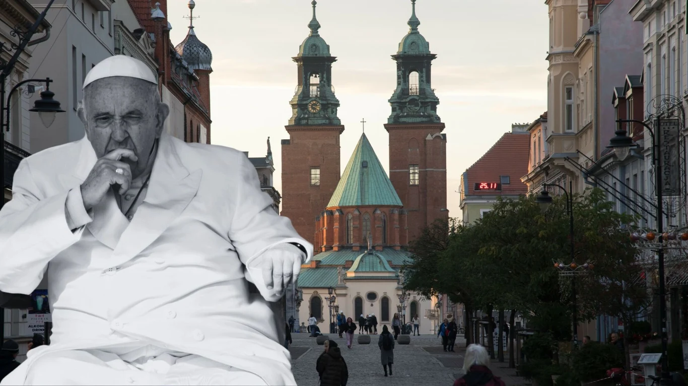 Gniezno. Jubileusz koronacji pierwszych królów Polski - przesłanie od papieża Postać w białym stroju papieskim na pierwszym planie, na tle ulicy z zabytkową katedrą i budynkami. Katedra ozdobiona dwoma wieżami widoczna w centralnej części zdjęcia.