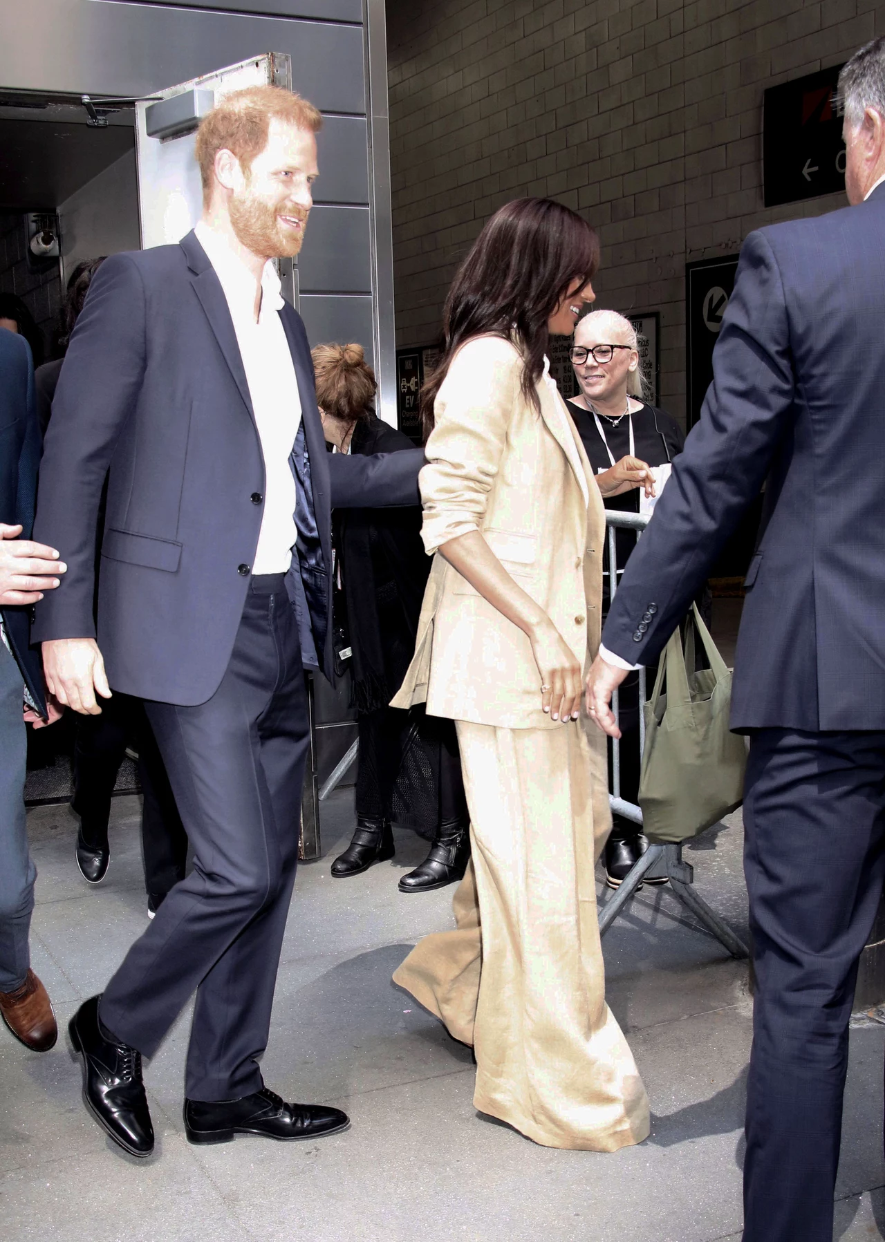 Harry i Meghan pojawili się na Time100 Summit w Nowym Jorku. Markle zignorowała wtedy czuły gest męża Para ubrana elegancko opuszcza budynek w otoczeniu innych osób, które towarzyszą im z uśmiechem.