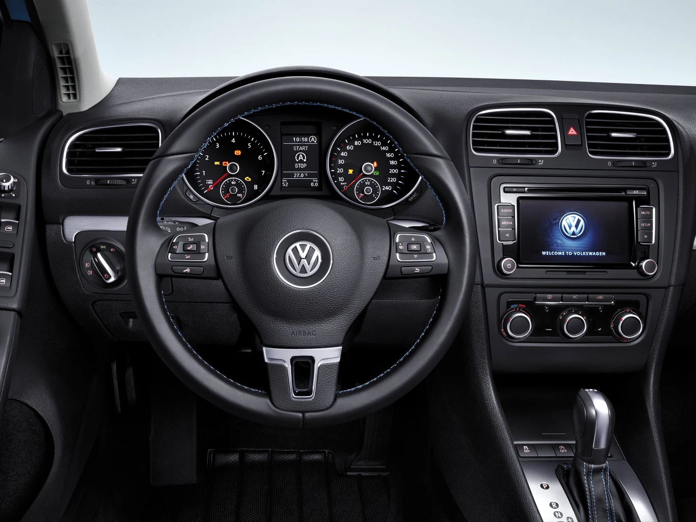 Wnętrze samochodu Volkswagen z widoczną kierownicą, zegarami na desce rozdzielczej i ekranem multimedialnym na centralnej konsoli.