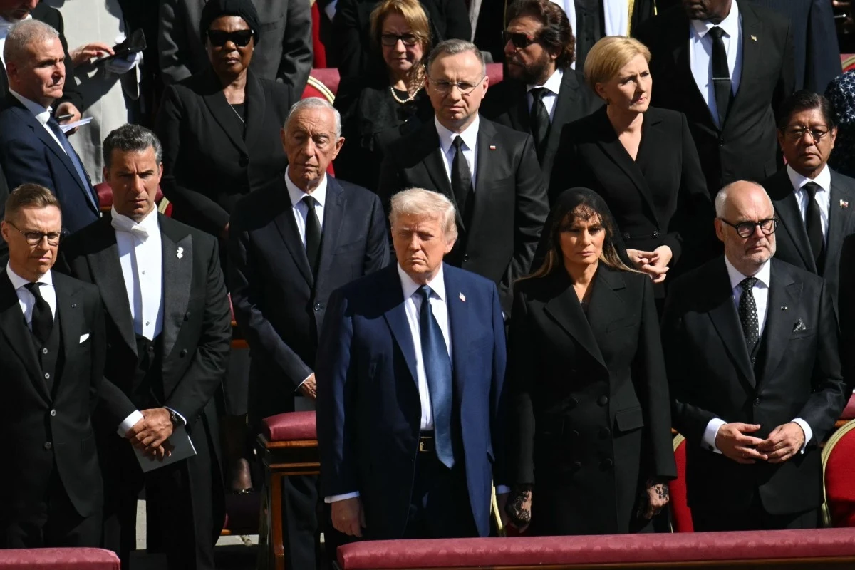 Delegacje z całego świata w Watykanie. Prezydenci, premierzy i koronowane głowy Grupa dostojnie ubranych osób stoi na zewnątrz w formalnej ceremonii, większość z nich ma poważne wyrazy twarzy i formalne stroje.