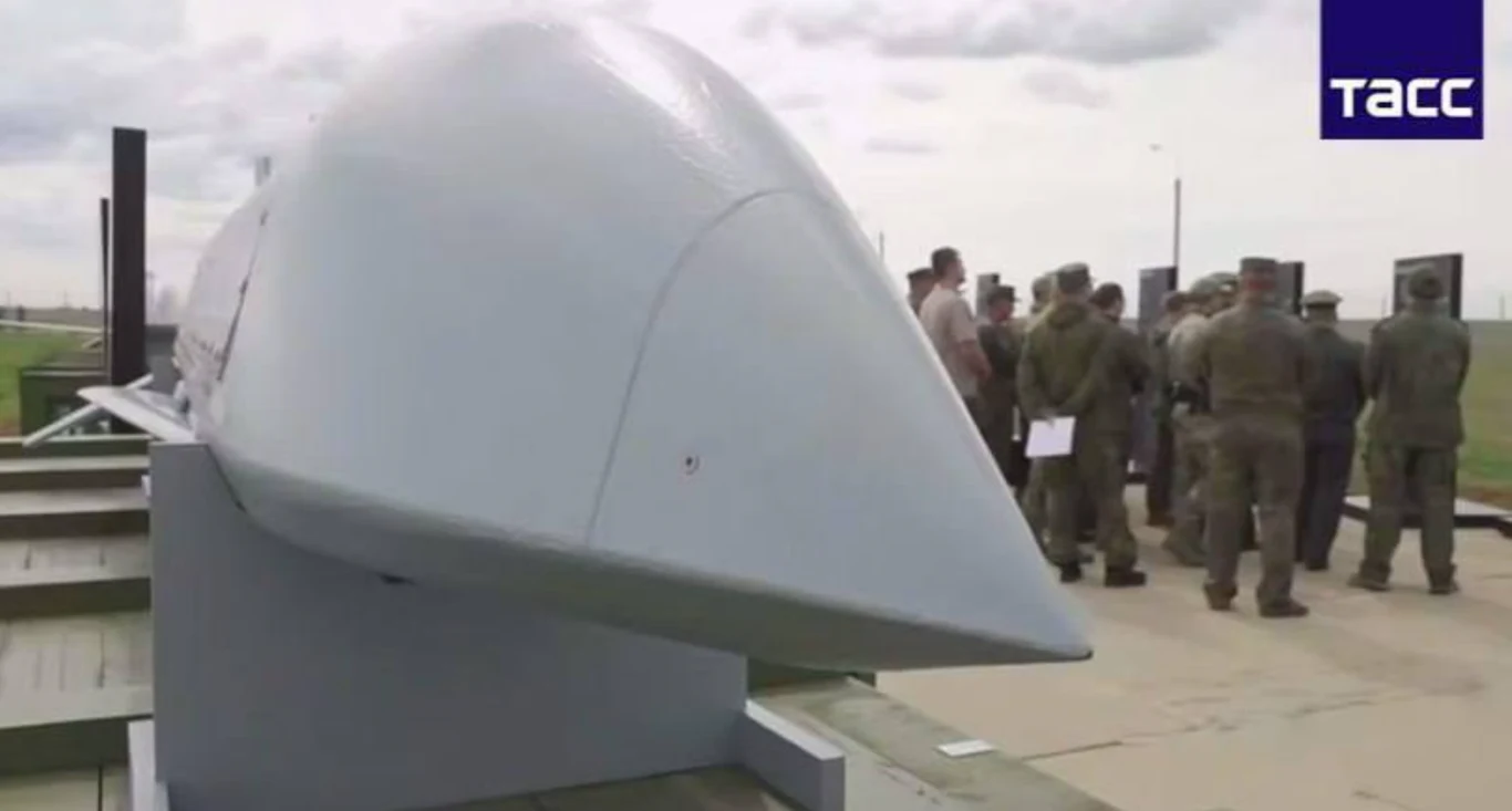 Screen z nagrania opublikowanego przez agencję TASS. Czy tak wygląda Banderol? Duża rakieta balistyczna z przodu, w tle grupa wojskowych w mundurach analizuje otoczenie. Na zdjęciu widoczne logo agencji prasowej Tass.