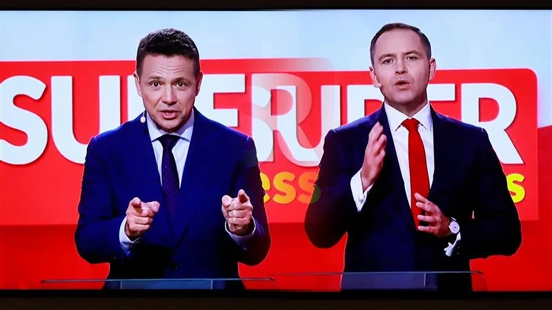 Rafał Trzaskowski i Karol Nawrocki podczas debaty, organizowanej przez "Super Express" 28.04.2025 Dwaj mężczyźni w garniturach przemawiają przed tablicą z napisem 'SURPER'. Ich wyraziste postawy i gestykulacja sugerują prowadzenie prezentacji lub przemówienia.