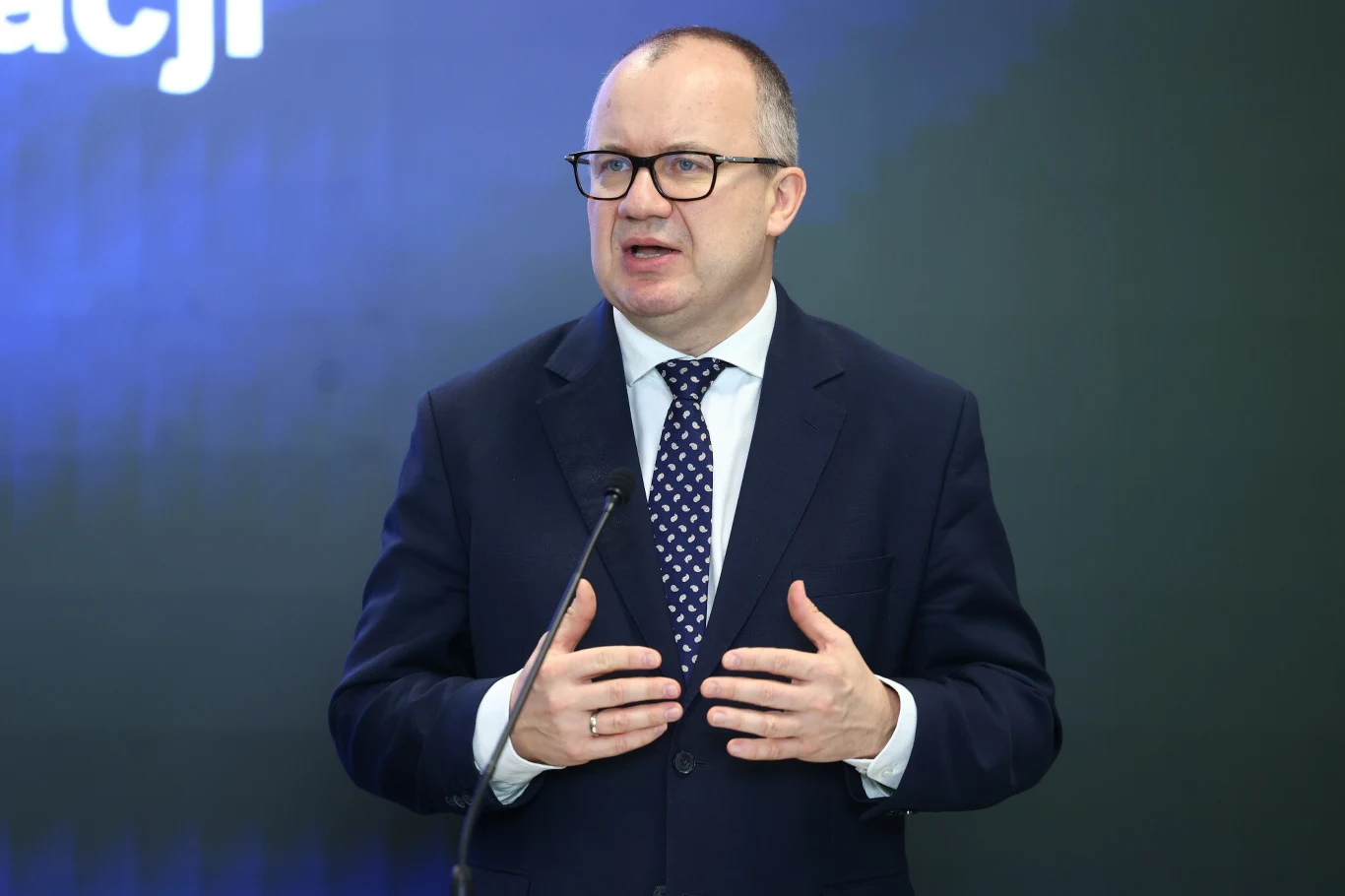 Adam Bodnar zabrał głos w sprawie śmierci lekarza w krakowskim szpitalu Mężczyzna w garniturze i krawacie, przemawiający na tle ciemnej ściany, z jedną ręką uniesioną jakby gestykulował. Jego twarz wyraża zaangażowanie w przekazywane treści.