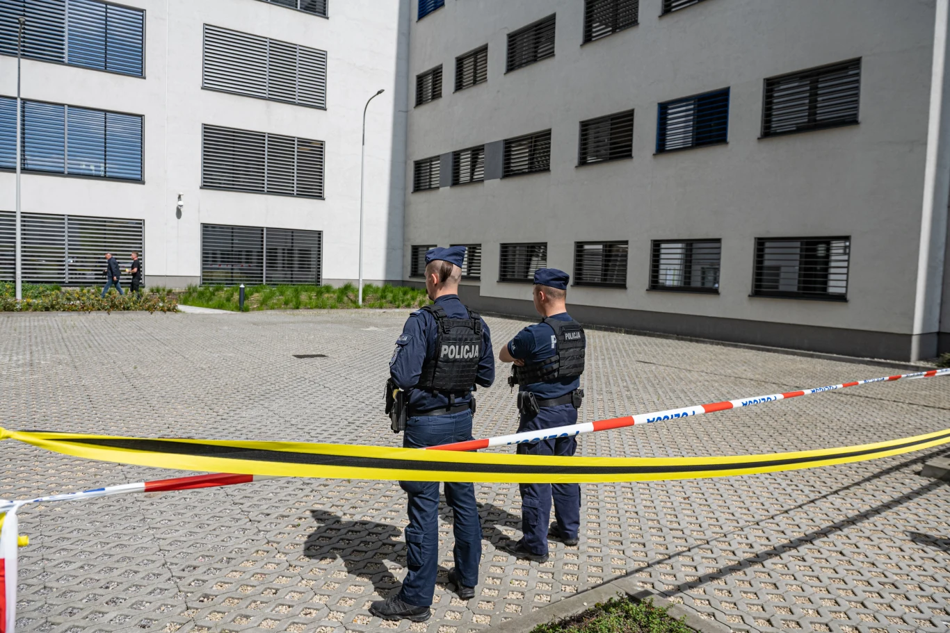 Do ataku doszło we wtorek rano Dwóch policjantów w kamizelkach, stojących na tle budynku. Przestrzeń oddzielona jest taśmą policyjną. Jasno otynkowany budynek z zamkniętymi oknami w tle.