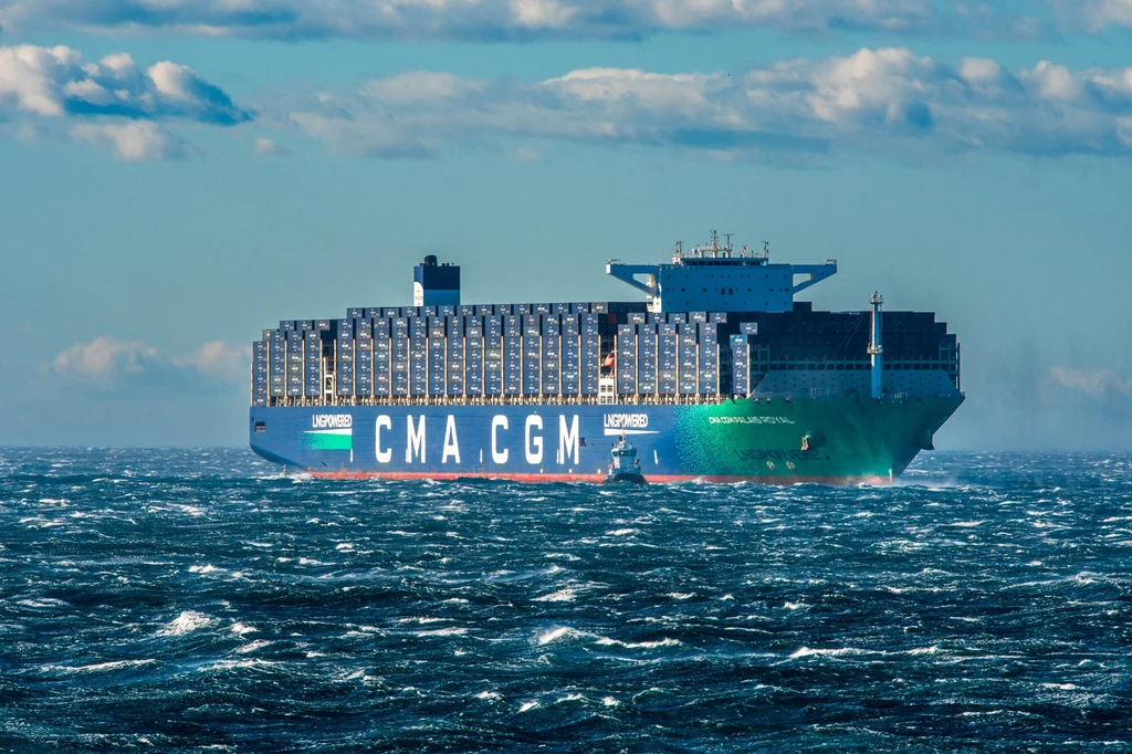 Ogromny tankowiec LNG u wybrzeży Francji Kontenerowiec CMA CGM płynie przez fale na otwartym morzu, niebo jest częściowo zachmurzone.