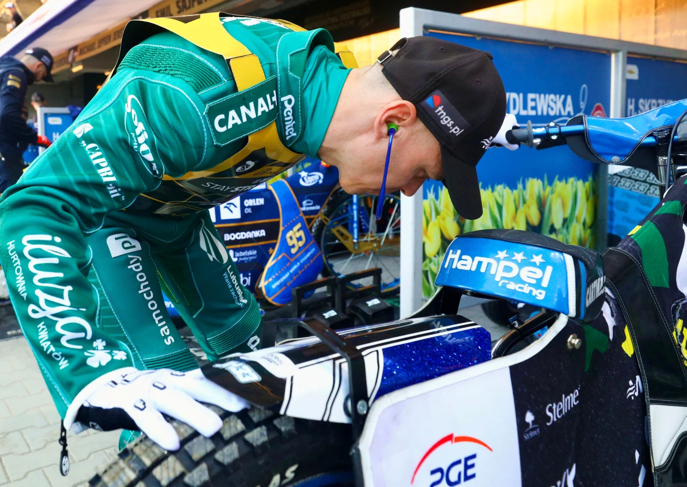 Jarosław Hampel sprawdza swój motocykl. Coś ewidentnie nie gra.