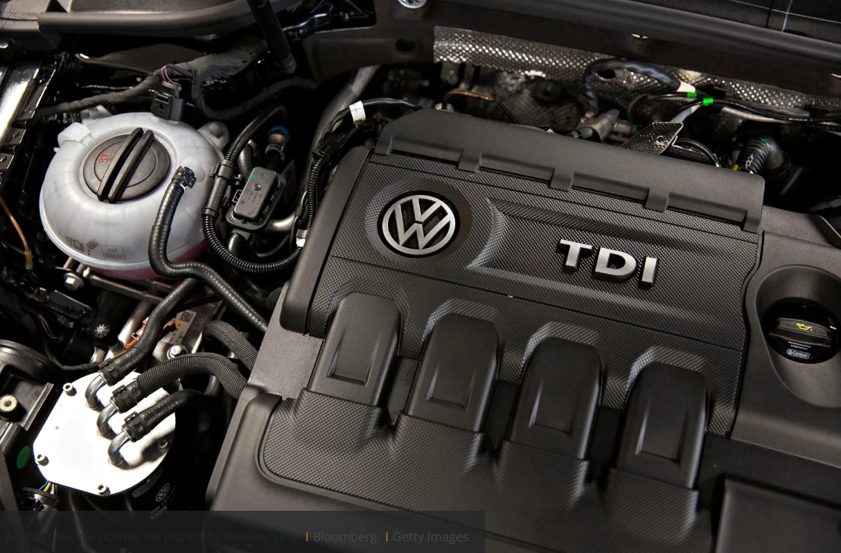 Silnik 2.0 TDI to chętnie wybierana jednostka przez Polaków. Silnik samochodowy z logo Volkswagen i oznaczeniem TDI. Widoczne detale mechaniczne, przewody i inne elementy konstrukcji pod maską pojazdu.