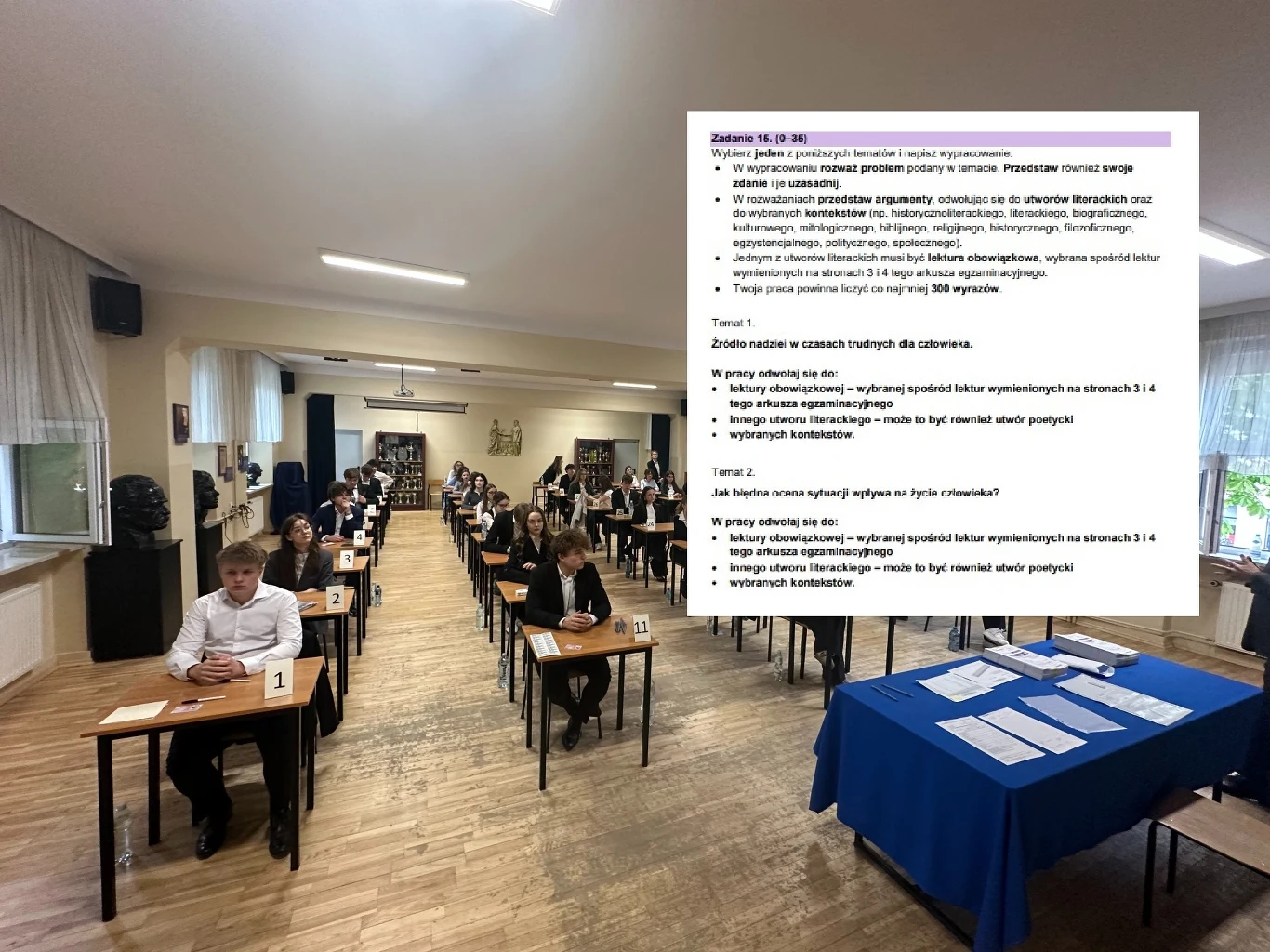 Matura 2025. Sztuczne inteligencje napisały wypracowania. Egzaminatorka ocenia. Zdjęcia: Arkusz CKE Sala egzaminacyjna wypełniona uczniami siedzącymi przy szkolnych ławkach, przed każdym z nich numerki i testy. Na stoliku po prawej stronie znajdują się dodatkowe materiały egzaminacyjne.