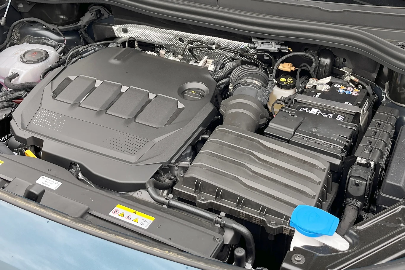 Które silniki diesla są najlepsze? Silnik samochodu z wyraźnym widokiem na jego podzespoły, w tym filtr powietrza, zbiorniczek wyrównawczy oraz różne przewody i złącza. Konstrukcja jest zadbana, a każdy element ma swoje określone miejsce.