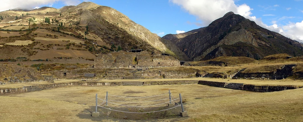 Stanowisko archeologiczne kultury Chavín jest wpisane na listę światowego dziedzictwa UNESCO. Badania tego obszaru ponownie doprowadziły do ciekawego odkrycia. Panorama górskiego krajobrazu z ruinami starożytnej budowli na pierwszym planie. W tle widać majestatyczne góry pod niebem pełnym chmur.