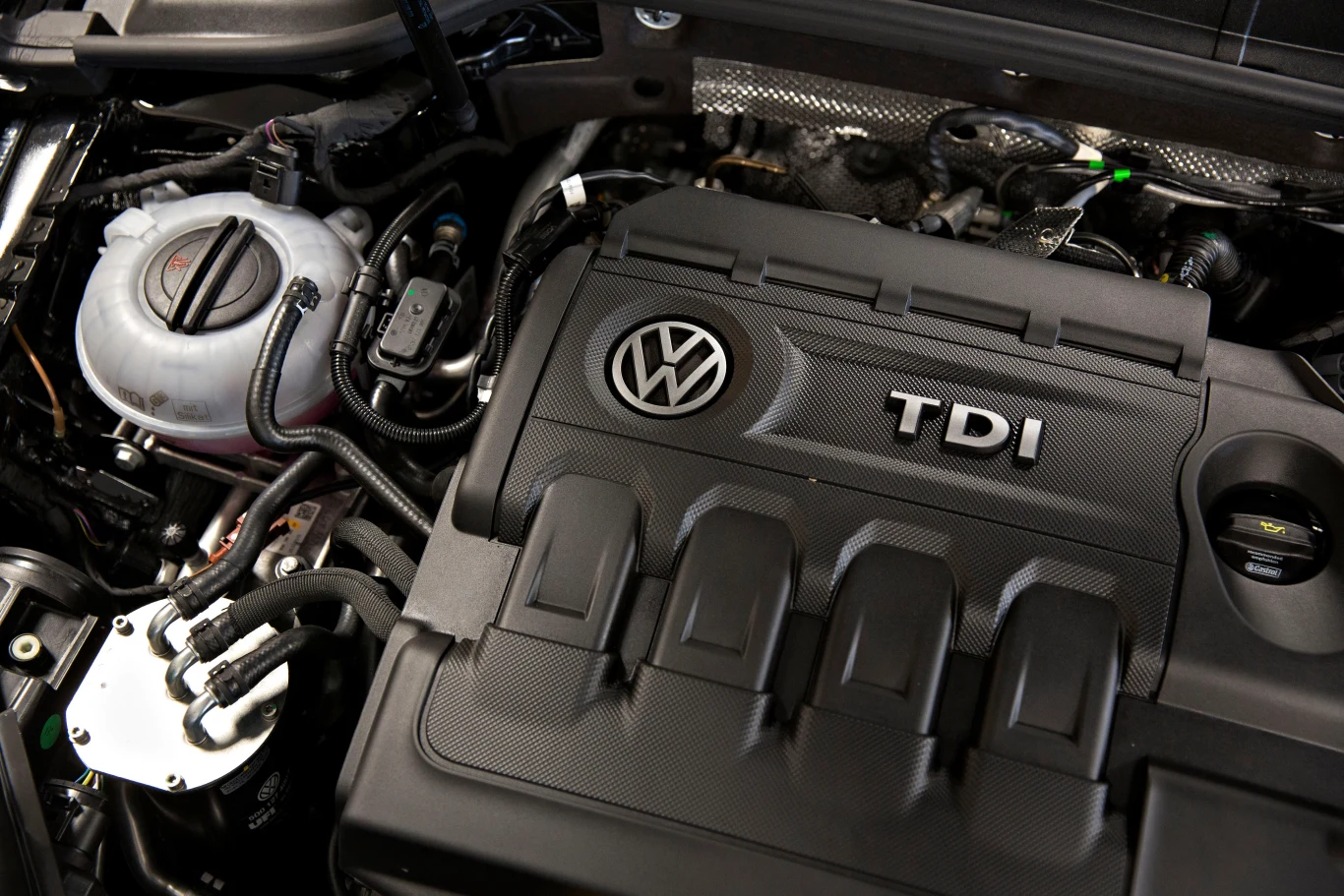20 tys. zł kary za auto spalinowe. Kierowcy mają niewiele czasu Silnik samochodowy TDI z logo Volkswagen, dobrze widoczny zamontowany wewnątrz pojazdu. Widoczne są przewody i różne elementy mechaniczne w przestrzeni silnika.