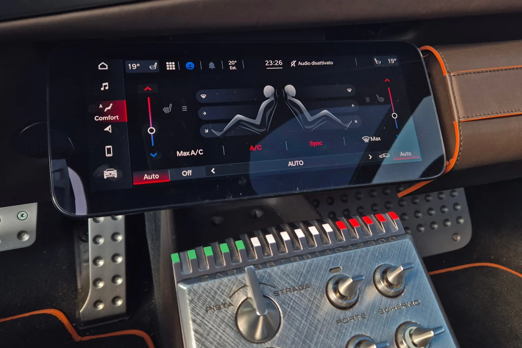 Alfa Romeo 33 Stradale Kokpit samochodu z nowoczesnym panelem dotykowym na konsoli centralnej. Wyświetlacz pokazuje ustawienia klimatyzacji i ogrzewania. Niżej znajduje się panel sterowania ze srebrnymi przełącznikami i pokrętłami.
