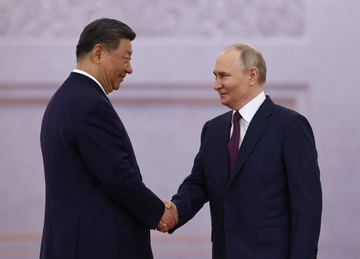 Spotkanie Xi Jinpinga i Władimira Putina; zdj. ilustracyjne Xi Jinping i Władimir Putin ściskają sobie dłonie w formalnym otoczeniu, obaj w garniturach