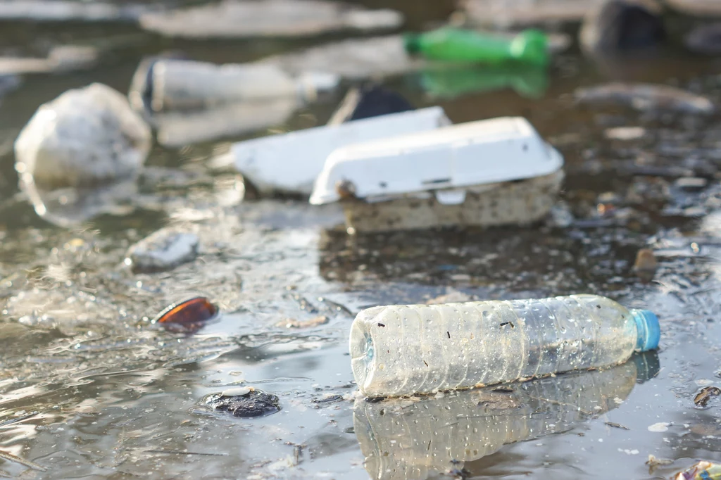 Zmniejszenie zanieczyszczenia wód jest celem strategii wodnej Plastikowe butelki i odpady pływające w zanieczyszczonej wodzie. Widoczne są różne rodzaje odpadów, takie jak opakowania i butelki, które tworzą nieestetyczny widok wskazujący na zanieczyszczenie środowiska.