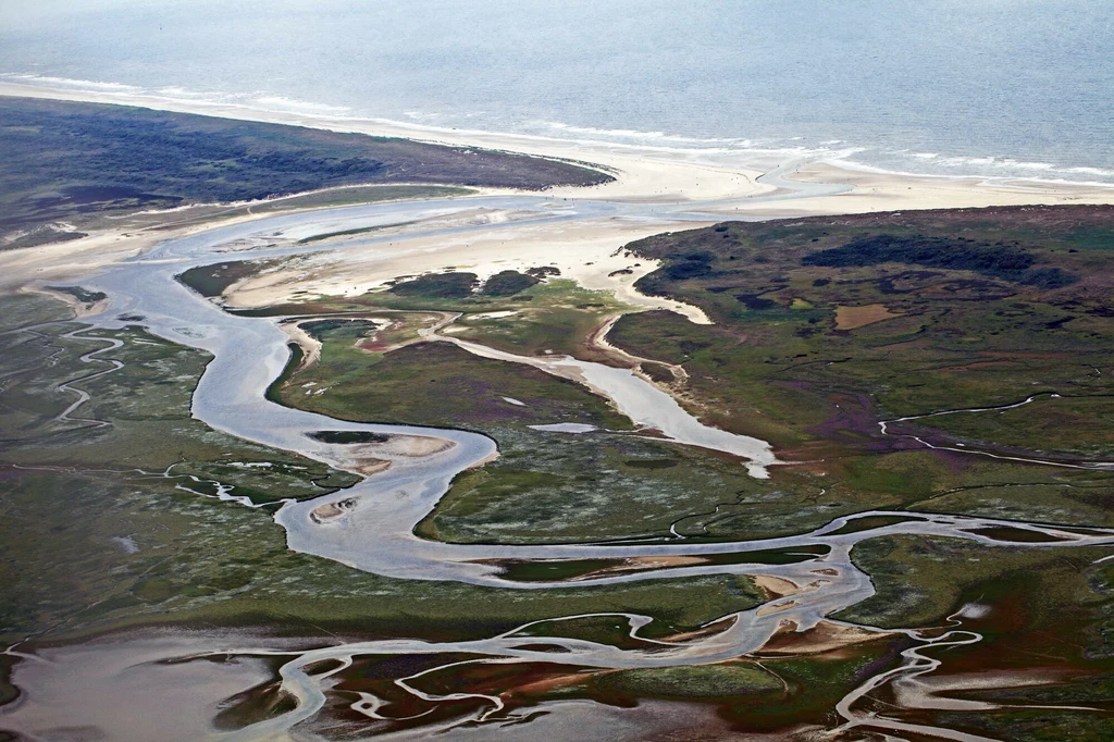 Aerial photography of the Slufter tidal inlet along the northwestern coastal perimeter of the Isle of Texel, Netherlands. Aerial photography of the Slufter tidal inlet along the northwestern coastal perimeter of the Isle of Texel, Netherlands.