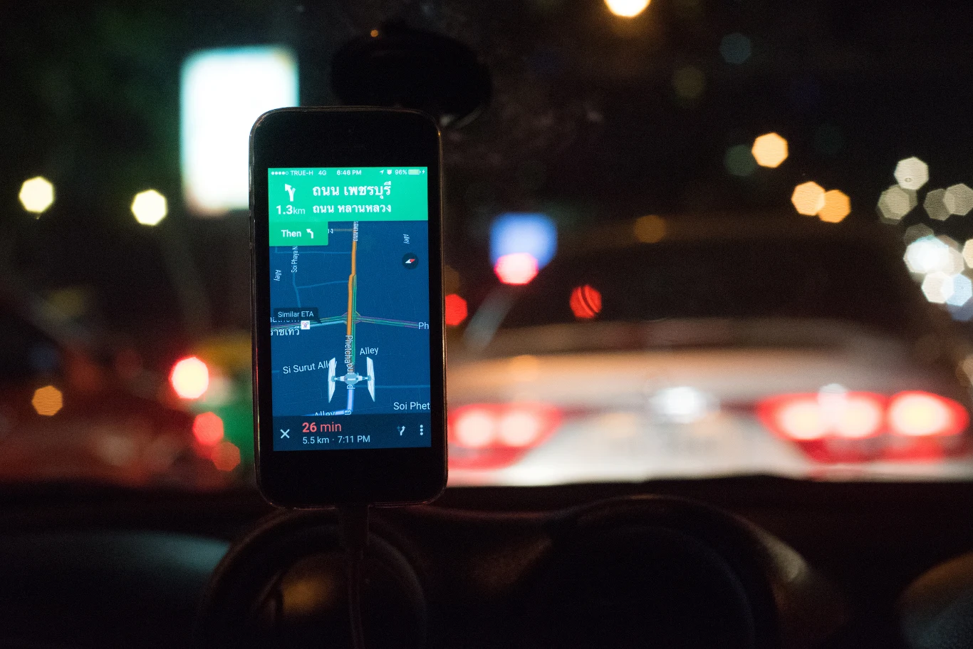 Google rewolucjonizuje sposób podejścia do zapisywania lokalizacji. Telefon zamontowany na desce rozdzielczej samochodu, wyświetlający nawigację GPS, pokazującą trasę w mieście nocą, z niewyraźnym widokiem na światła samochodów w ruchu ulicznym w tle.